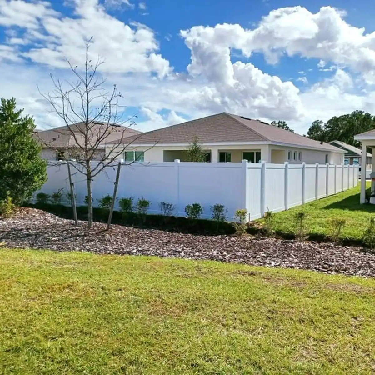 White vinyl privacy fence enclosing the side yard of a Central Florida home