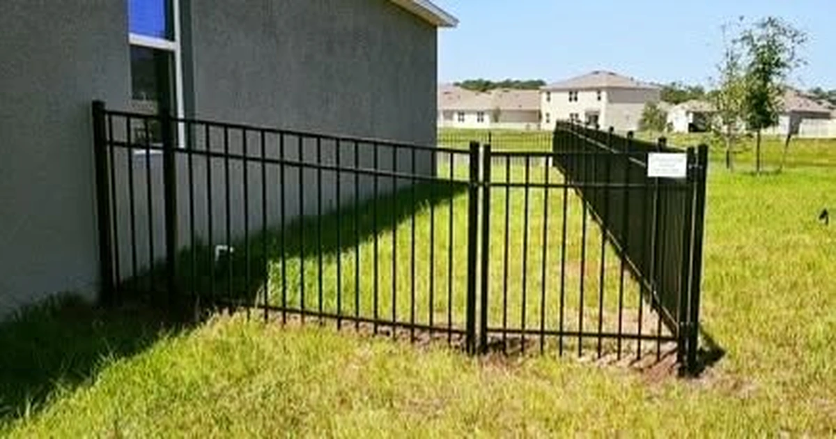 Black aluminum gate in a St. Cloud fence line near the lake