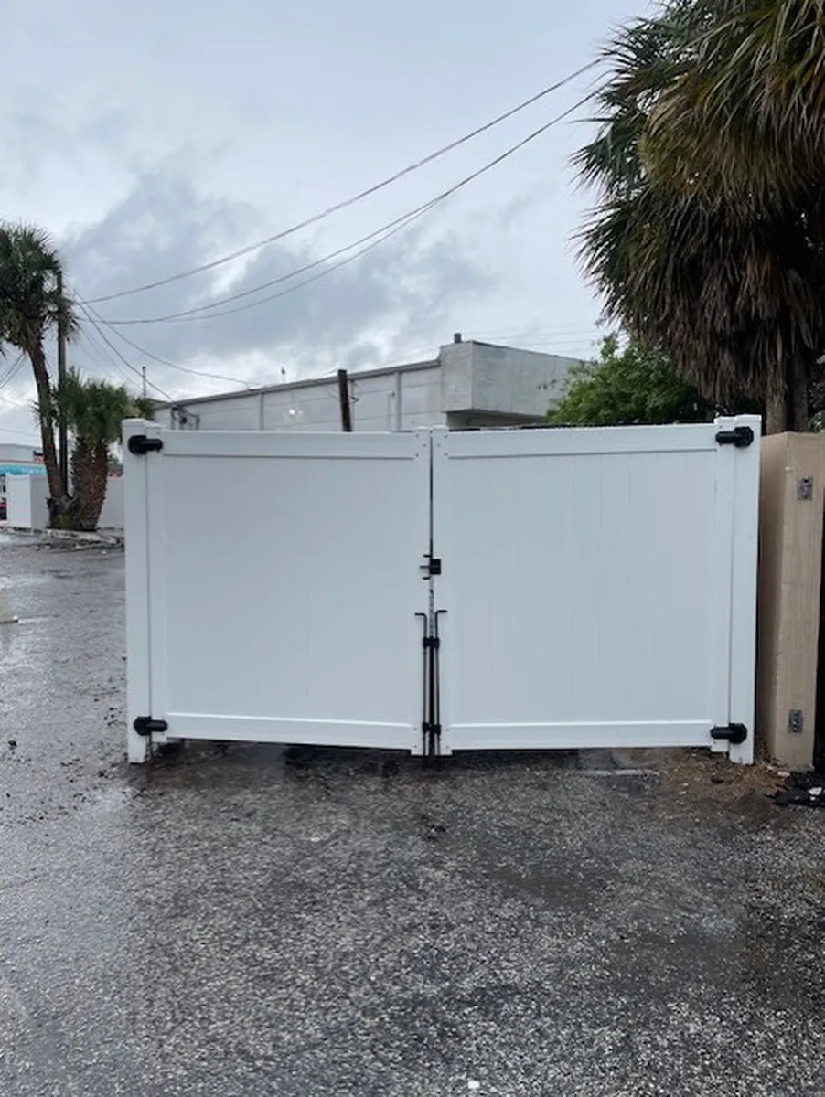 Vinyl dumpster enclosure gate with drop rods at an Orlando business