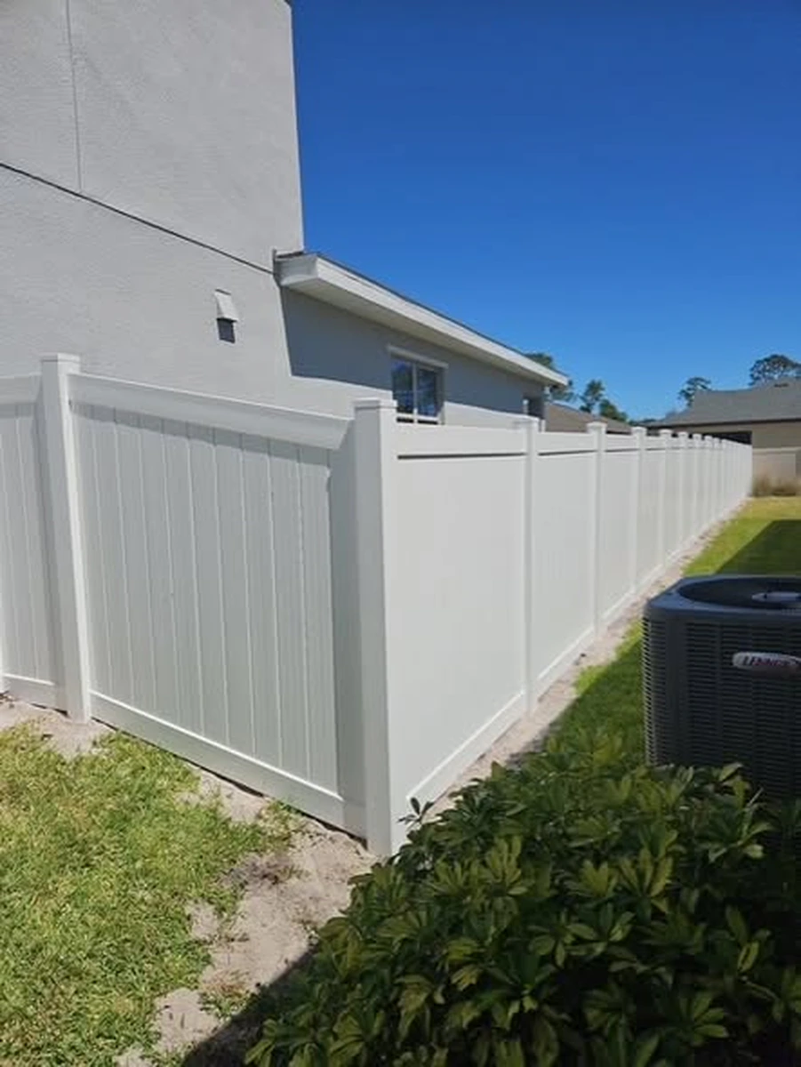 White vinyl fence along the side of a two story Altamonte Springs home past the AC unit