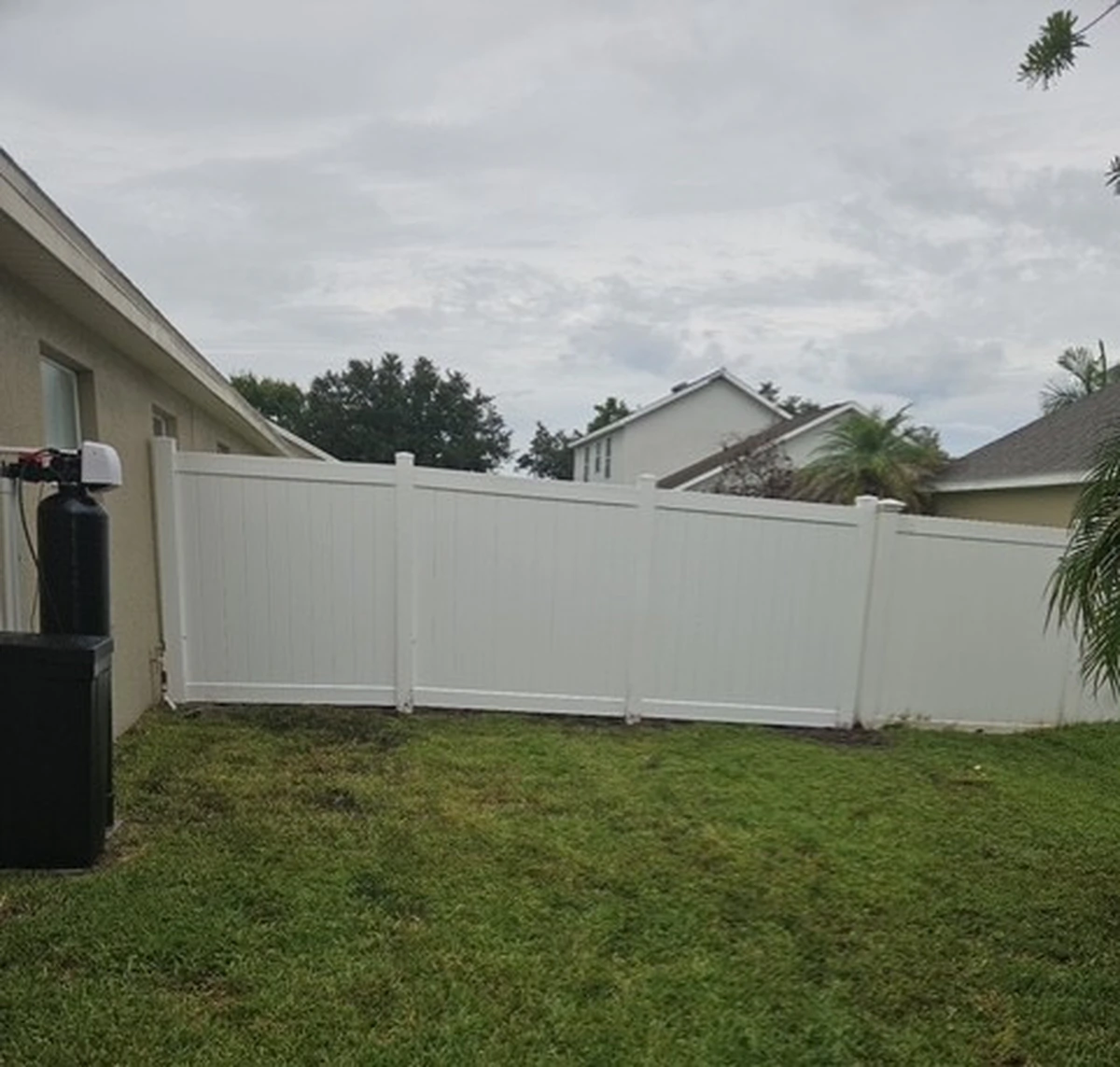 White vinyl privacy fence following a slope in a St. Cloud back yard