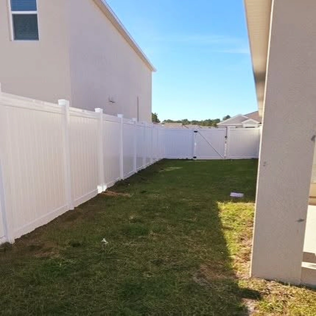 White vinyl privacy fence fully enclosing an Orlando back yard