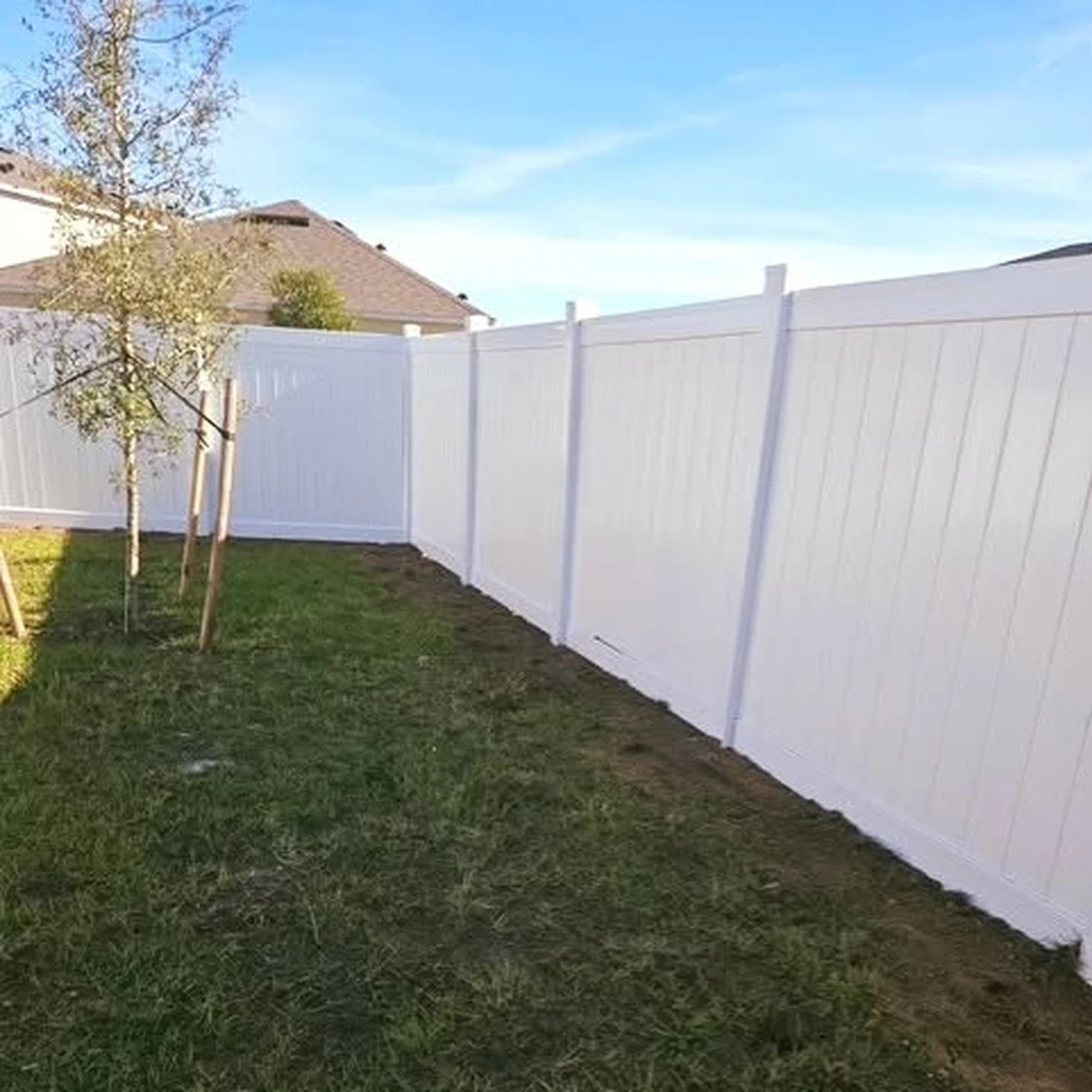 White vinyl privacy fence along the right side of an Orlando back yard