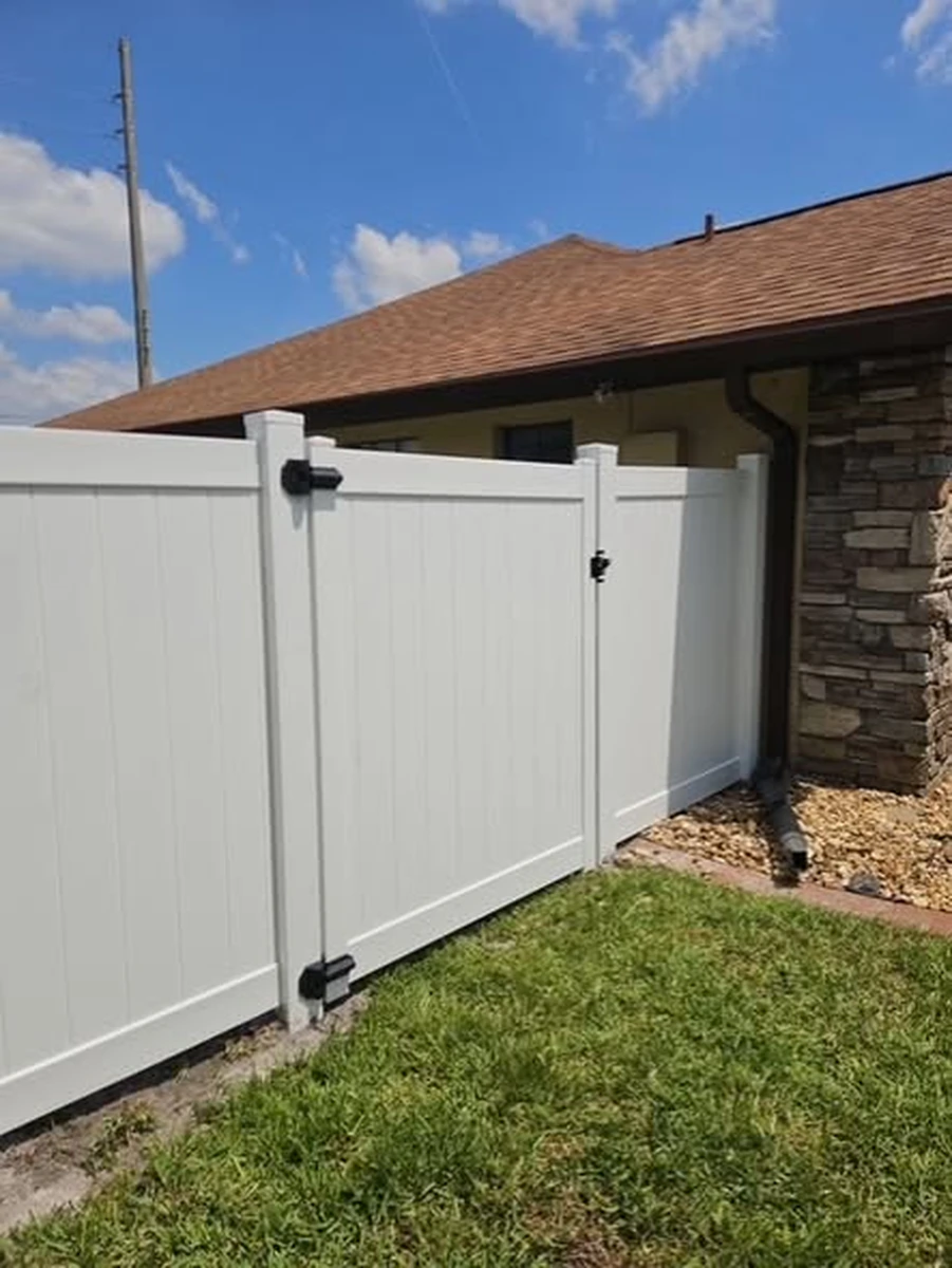 White vinyl walk gate beside a stone veneer corner at a Windermere home