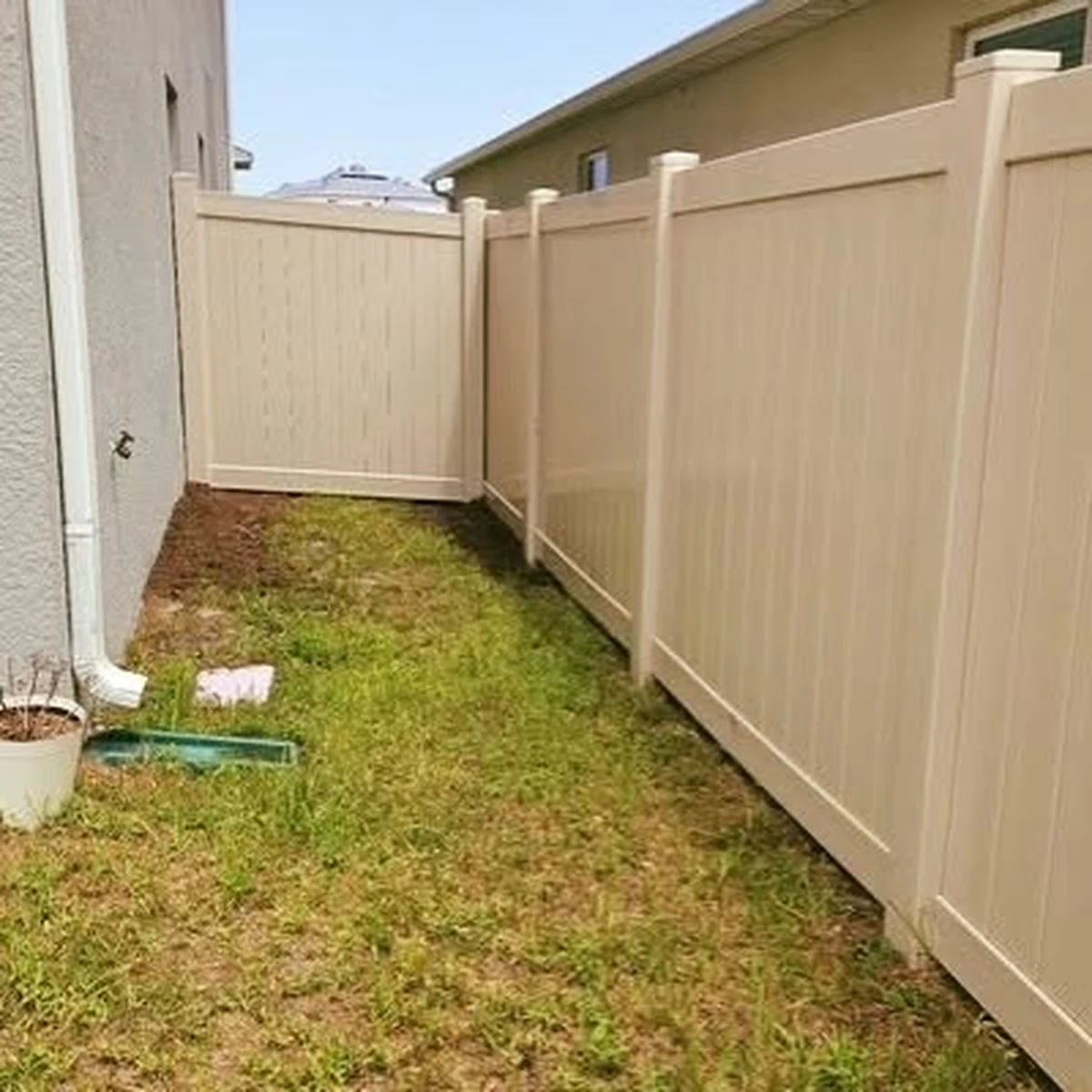 White vinyl privacy fence wrapping the corner of a Winter Garden back yard